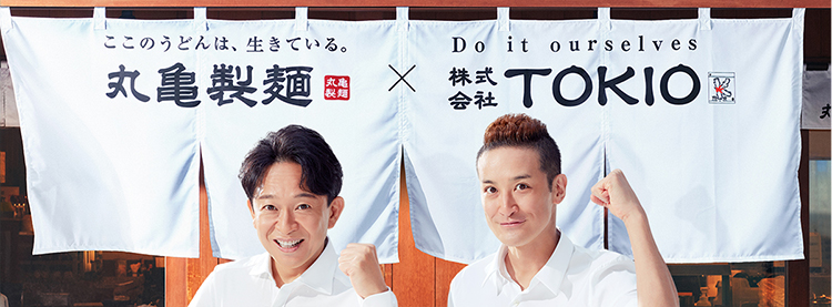 丸亀製麺✕株式会社TOKIOの暖簾を前にガッツポーズを決めるTOKIOの2人